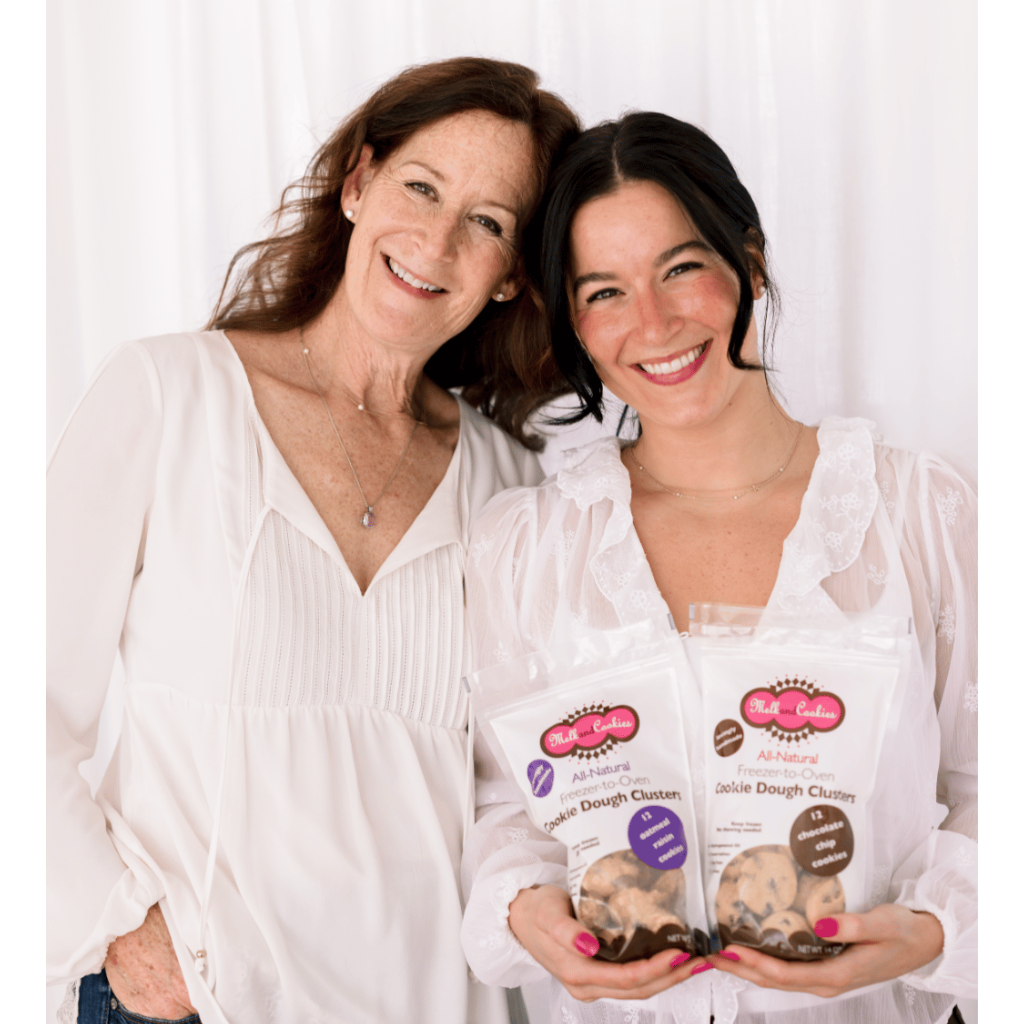 Two women holding bags of cookies with a white background